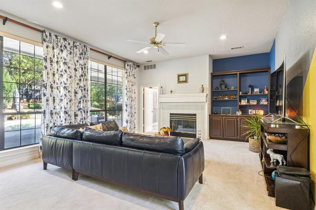 3825 Montecito Drive Denton, TX 76205 - Photo 15 of 37 a living room with furniture a flat screen tv and a fireplace