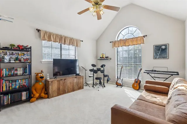 a living room with furniture a flat screen tv and a window