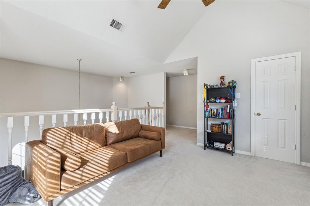 3825 Montecito Drive Denton, TX 76205 - Photo 26 of 37 a living room with furniture and a book shelf