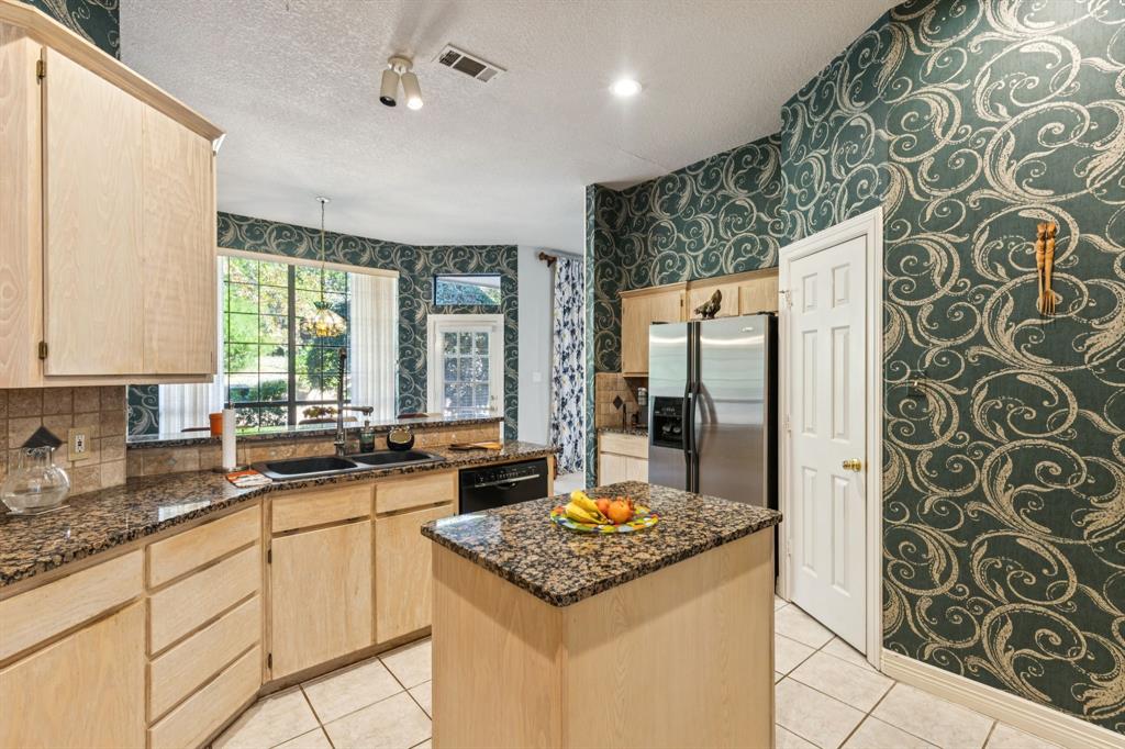 3825 Montecito Drive Denton, TX 76205 - Photo 10 of 37 a kitchen with a stove a refrigerator and a granite counter tops