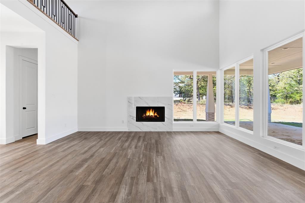 1552 Lakeridge Boulevard Sunset, TX 76270 - Photo 11 of 33 a view of an empty room with wooden floor and a window