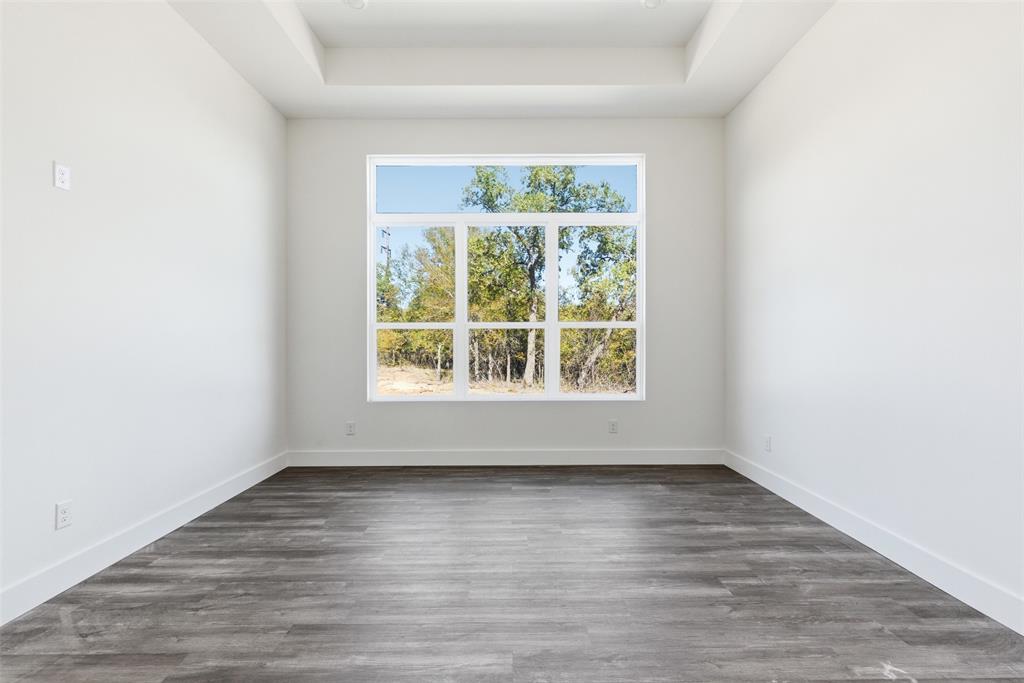 1552 Lakeridge Boulevard Sunset, TX 76270 - Photo 15 of 33 an empty room with wooden floor and a window