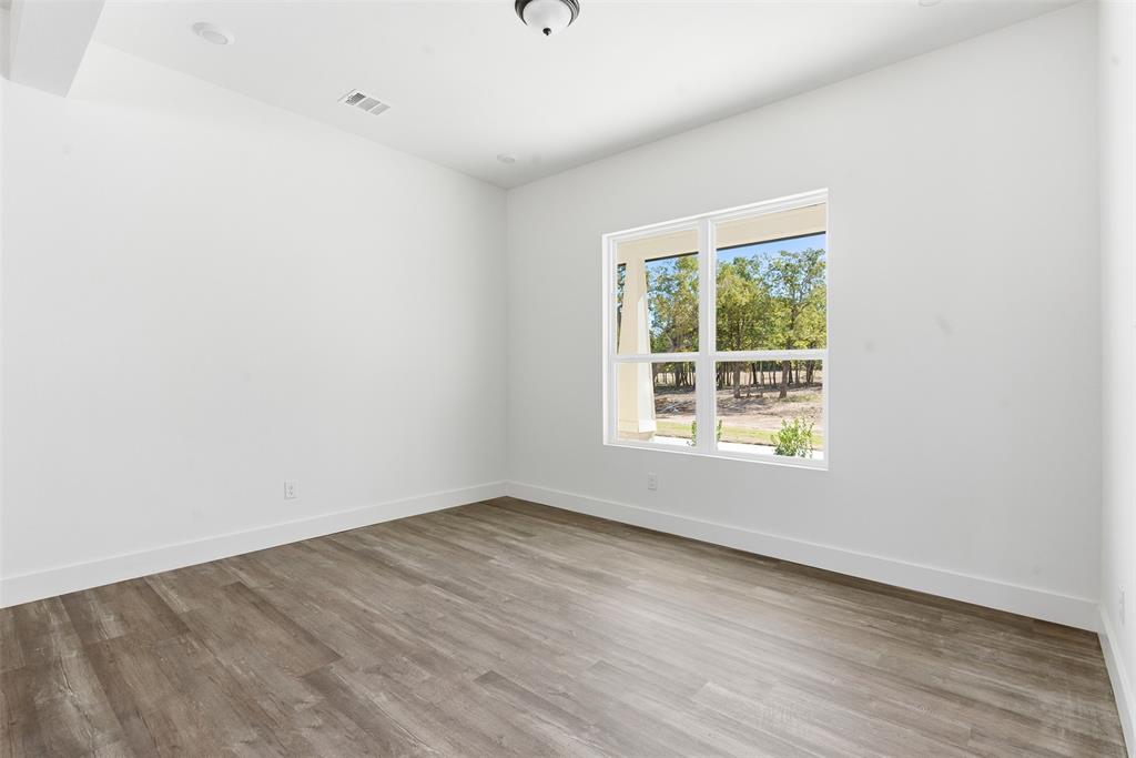 1552 Lakeridge Boulevard Sunset, TX 76270 - Photo 16 of 33 an empty room with wooden floor and windows