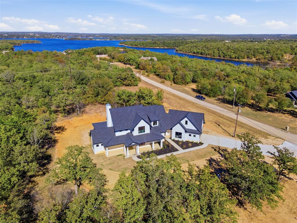 1552 Lakeridge Boulevard Sunset, TX 76270 - Photo 3 of 33 an aerial view of a house with a garden and lake view