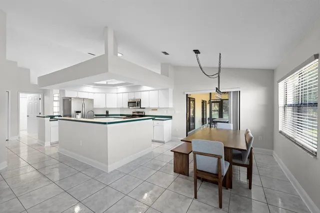 a kitchen with a refrigerator and white cabinets