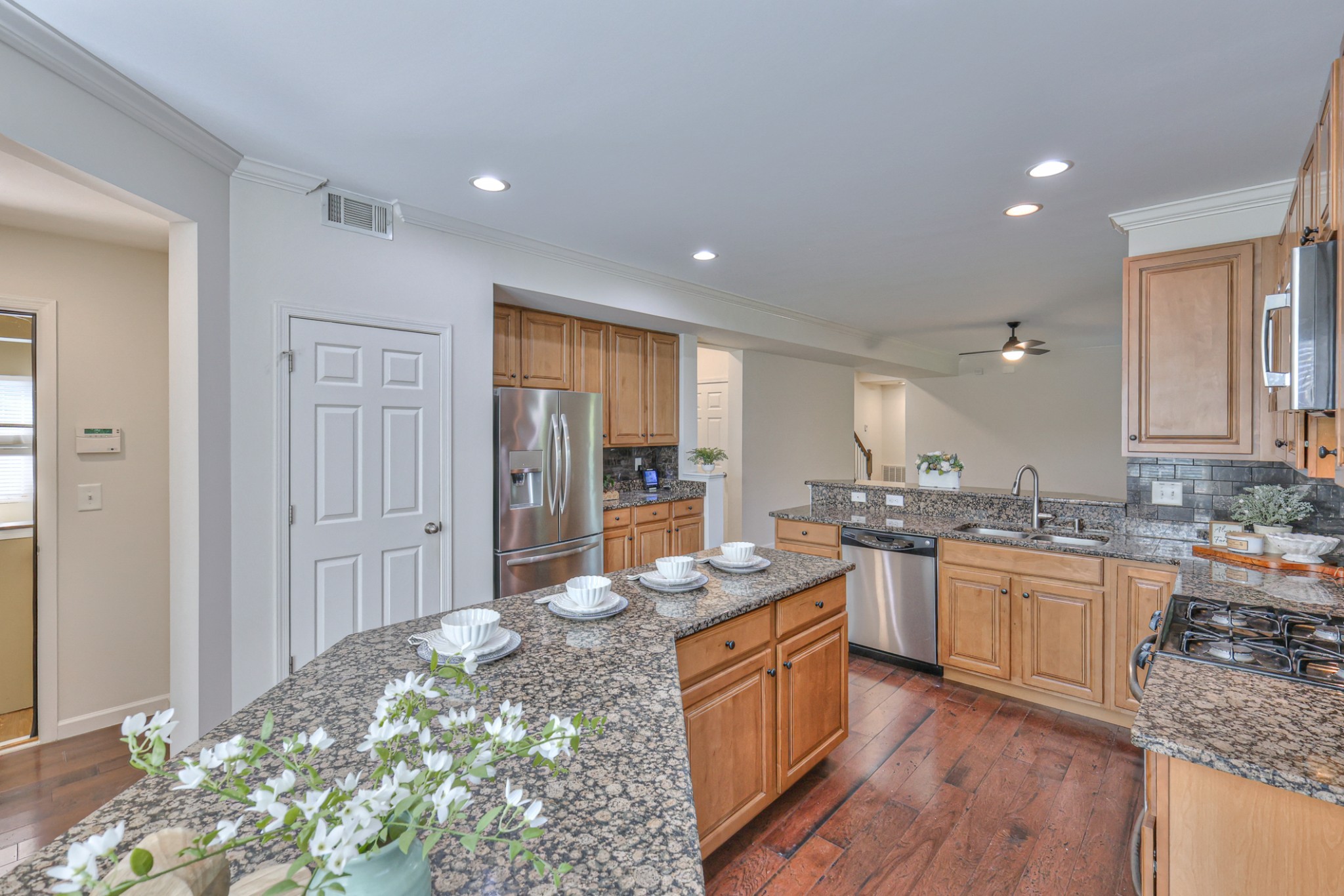 3104 Rutgers Pass Nolensville, TN 37135 - Photo 24 of 66 a large kitchen with kitchen island granite countertop a sink and dishwasher stove with wooden floor