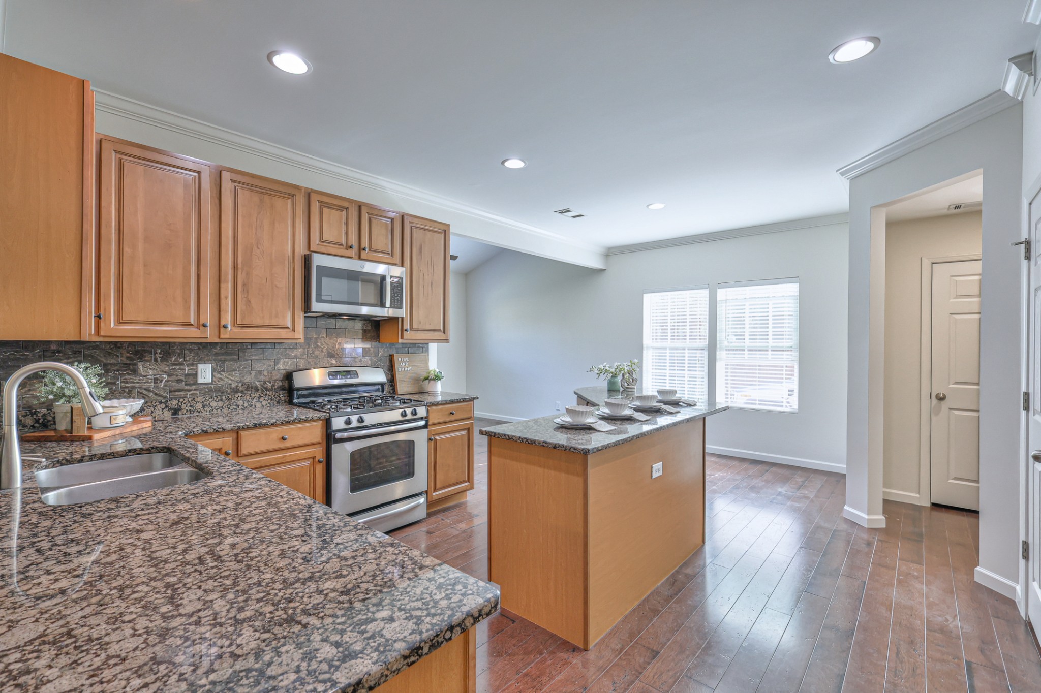 3104 Rutgers Pass Nolensville, TN 37135 - Photo 25 of 66 a kitchen with stainless steel appliances granite countertop a stove top oven a sink dishwasher and wooden cabinets with wooden floor