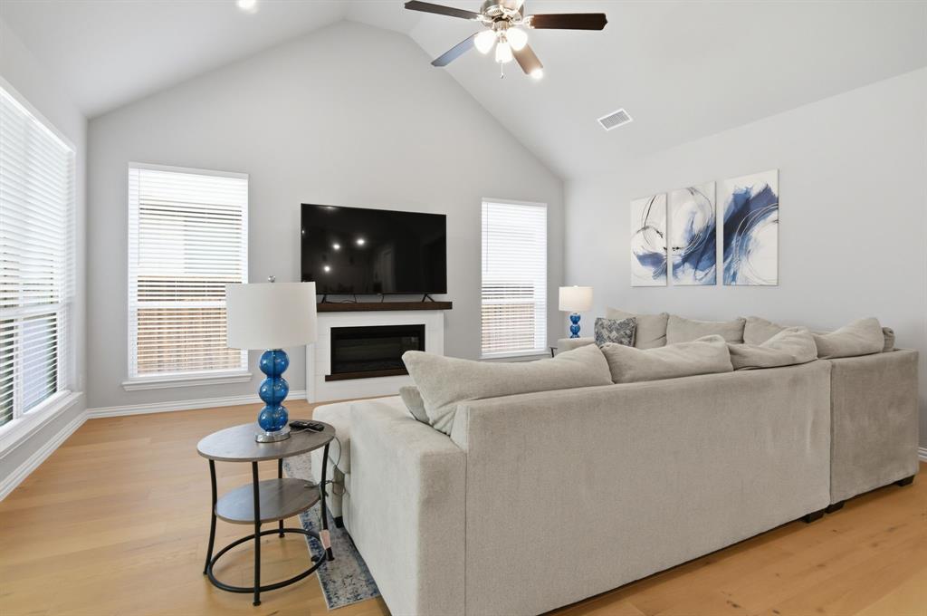 910 Winter Cherry Lane Haslet, TX 76052 - Photo 12 of 40 a living room with furniture a flat screen tv and a fireplace