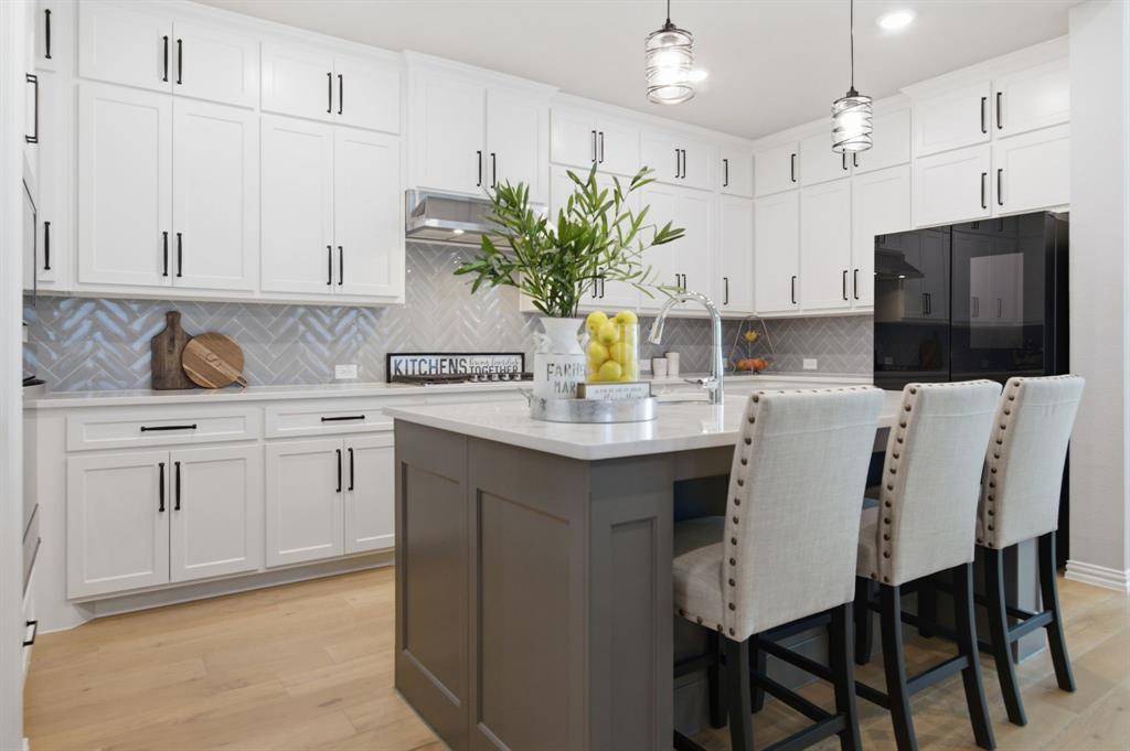 910 Winter Cherry Lane Haslet, TX 76052 - Photo 15 of 40 a kitchen with white cabinets and stainless steel appliances