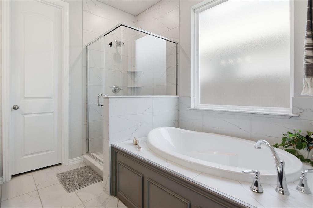 910 Winter Cherry Lane Haslet, TX 76052 - Photo 22 of 40 a bathroom with a tub and shower