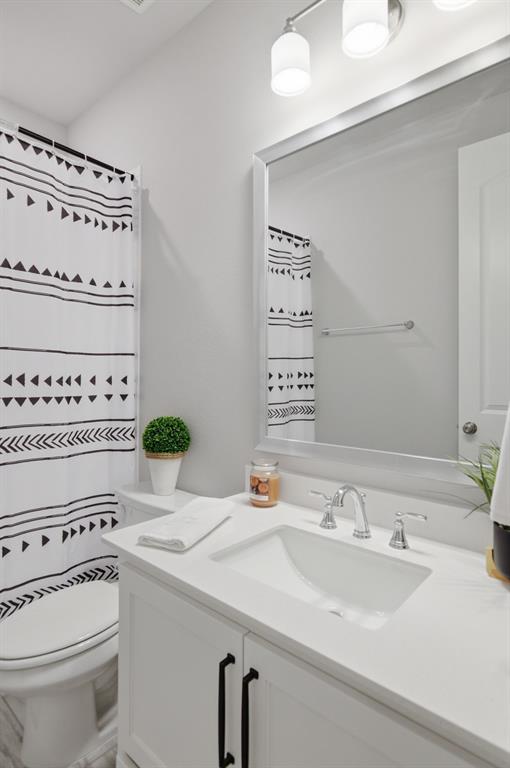 910 Winter Cherry Lane Haslet, TX 76052 - Photo 26 of 40 a bathroom with a sink a toilet and a mirror