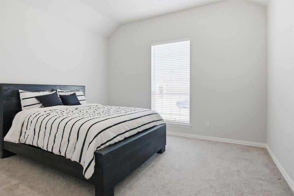 910 Winter Cherry Lane Haslet, TX 76052 - Photo 27 of 40 a spacious bedroom with a bed and a window