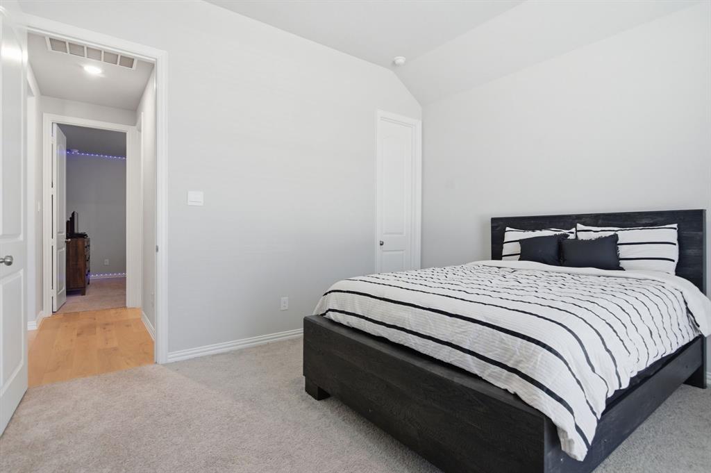910 Winter Cherry Lane Haslet, TX 76052 - Photo 28 of 40 a bedroom with a bed and lamp