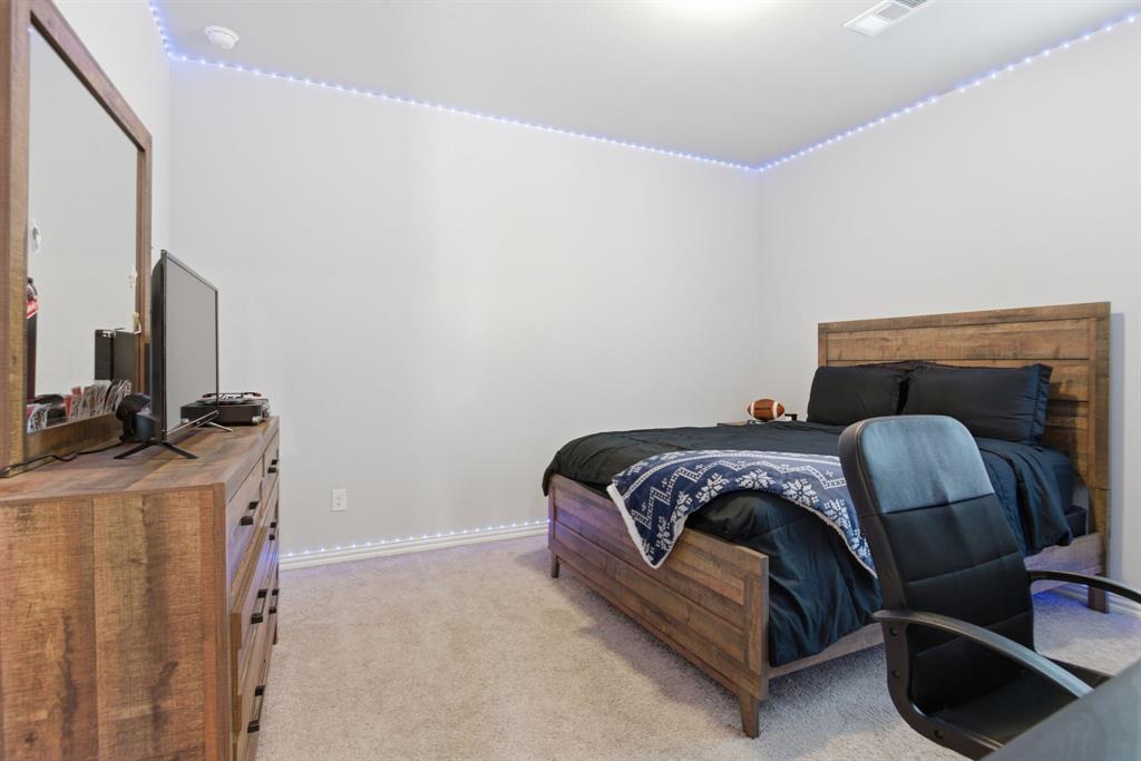 910 Winter Cherry Lane Haslet, TX 76052 - Photo 29 of 40 a bedroom with a bed and a flat screen tv