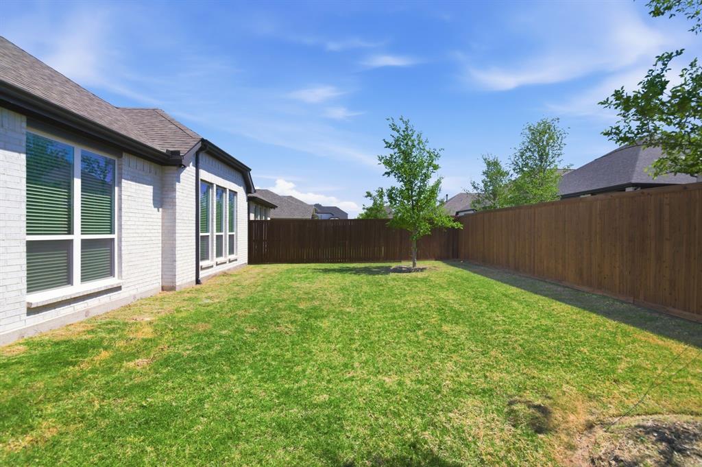 910 Winter Cherry Lane Haslet, TX 76052 - Photo 35 of 40 a view of a backyard with potted plants and wooden fence