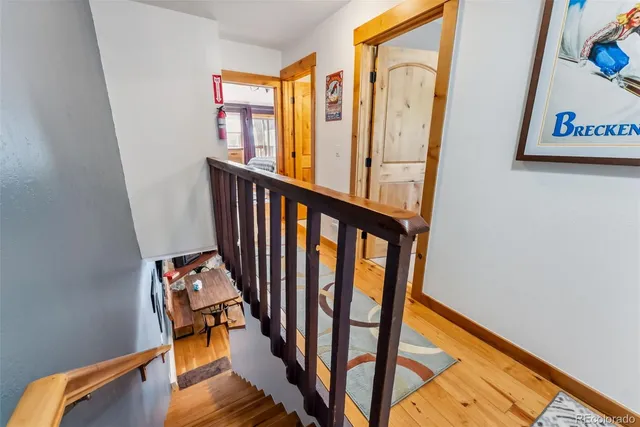 a view of a hallway with wooden floor and staircase