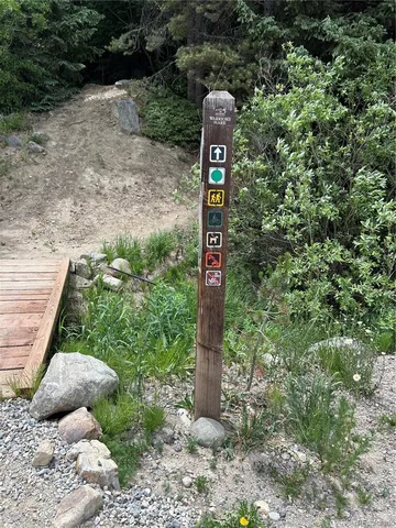 a front of a house with a tree and sign of street