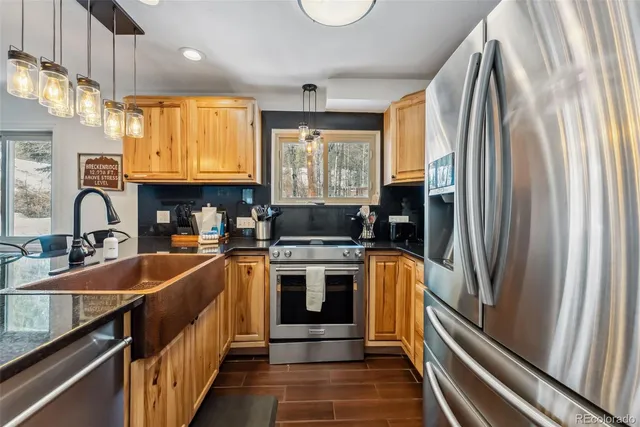 a kitchen with stainless steel appliances granite countertop a sink stove and refrigerator