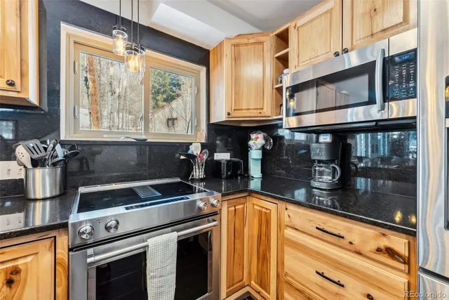 a kitchen with granite countertop a stove and a sink