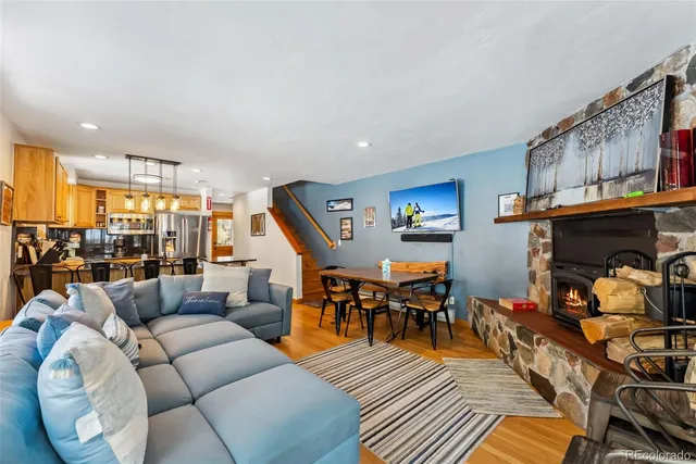 a living room with furniture a fireplace and a large window