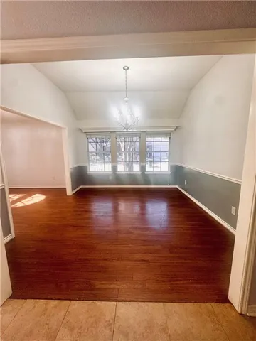 view of an empty room with wooden floor and a window