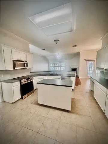 a large kitchen with stainless steel appliances granite countertop a stove a sink dishwasher and a refrigerator