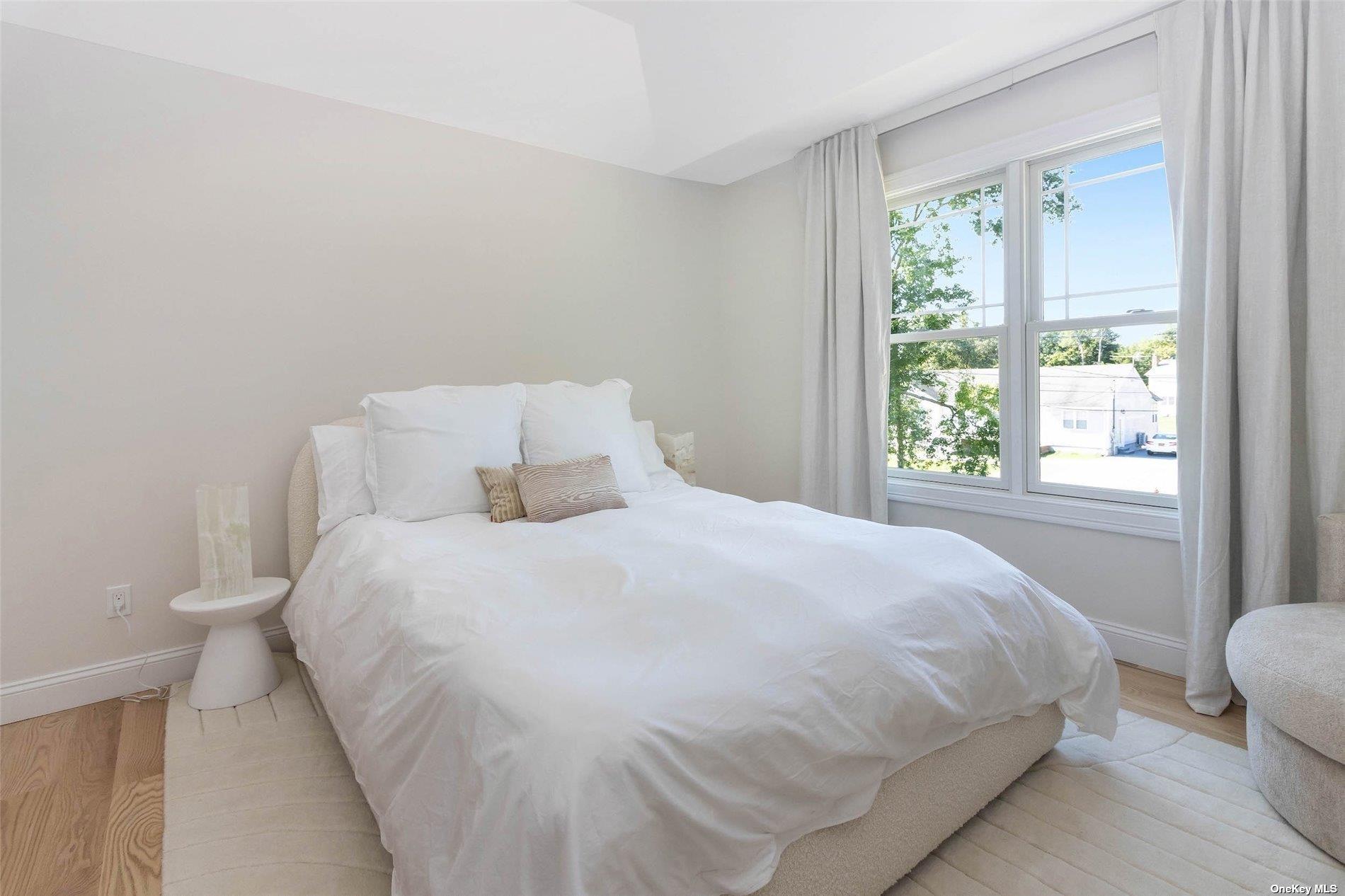 950 Tasker Lane Greenport, NY 11944 - Photo 22 of 37 a large bed sitting in a bedroom next to a window