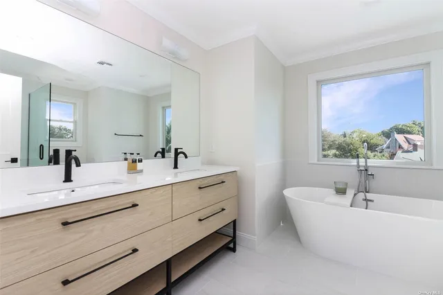 a bathroom with a double vanity sink and a window