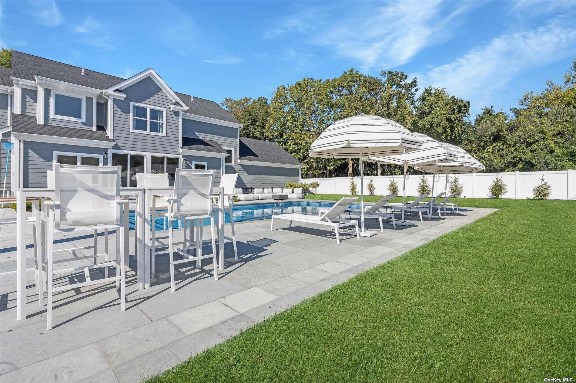 950 Tasker Lane Greenport, NY 11944 - Photo 31 of 37 a patio with a table and chairs under an umbrella