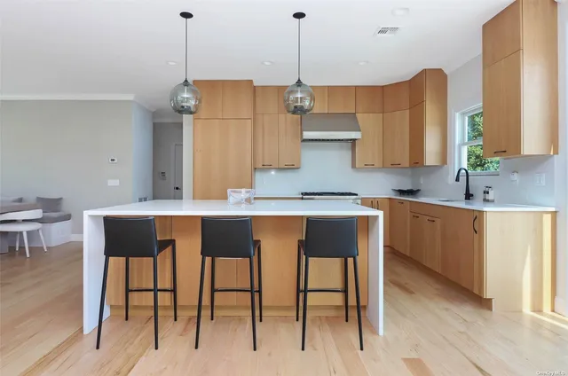 a kitchen with kitchen island granite countertop a sink a center island and cabinets