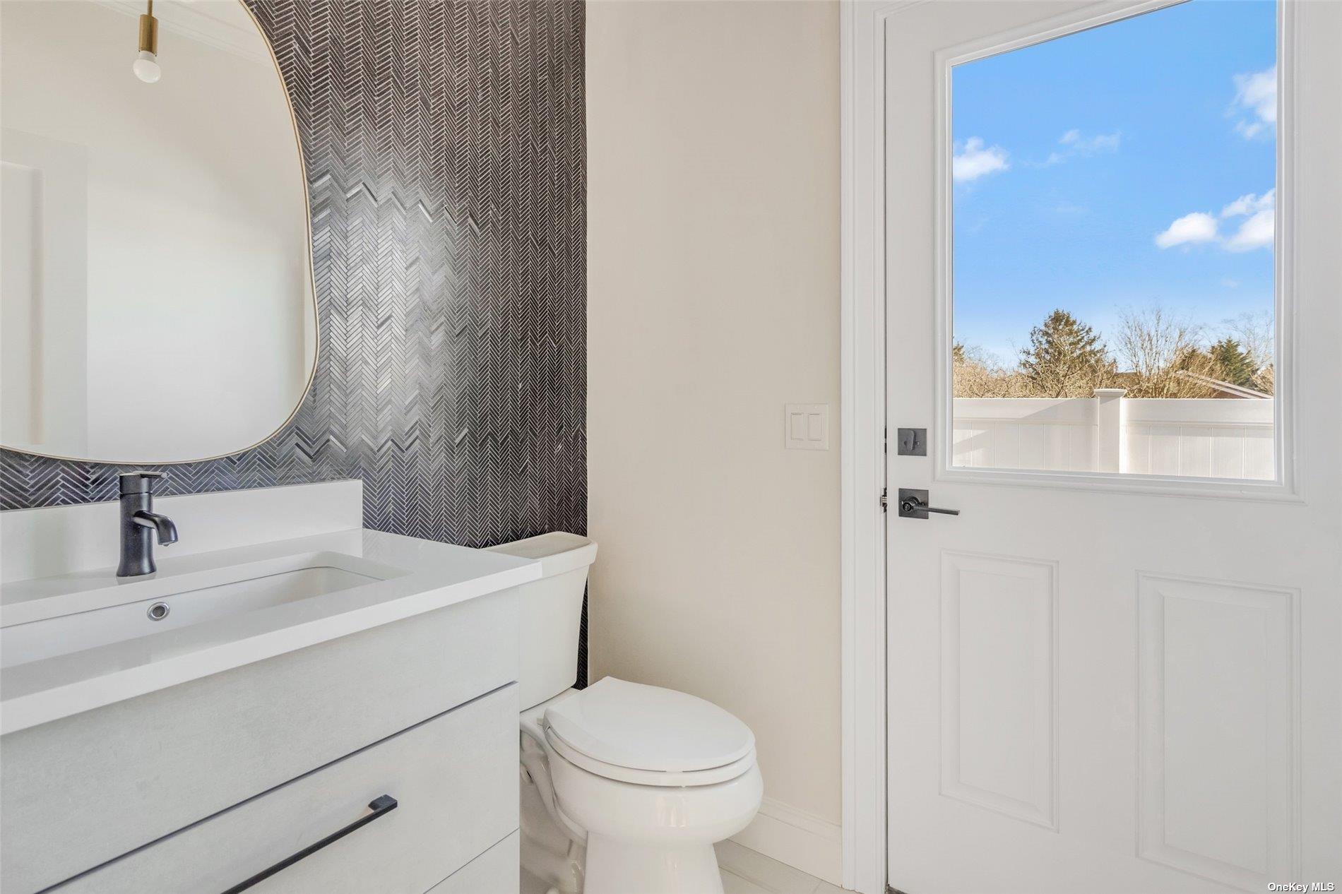 950 Tasker Lane Greenport, NY 11944 - Photo 8 of 37 a bathroom with a sink and a mirror