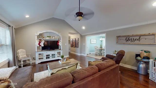 a living room with furniture a flat screen tv and a window