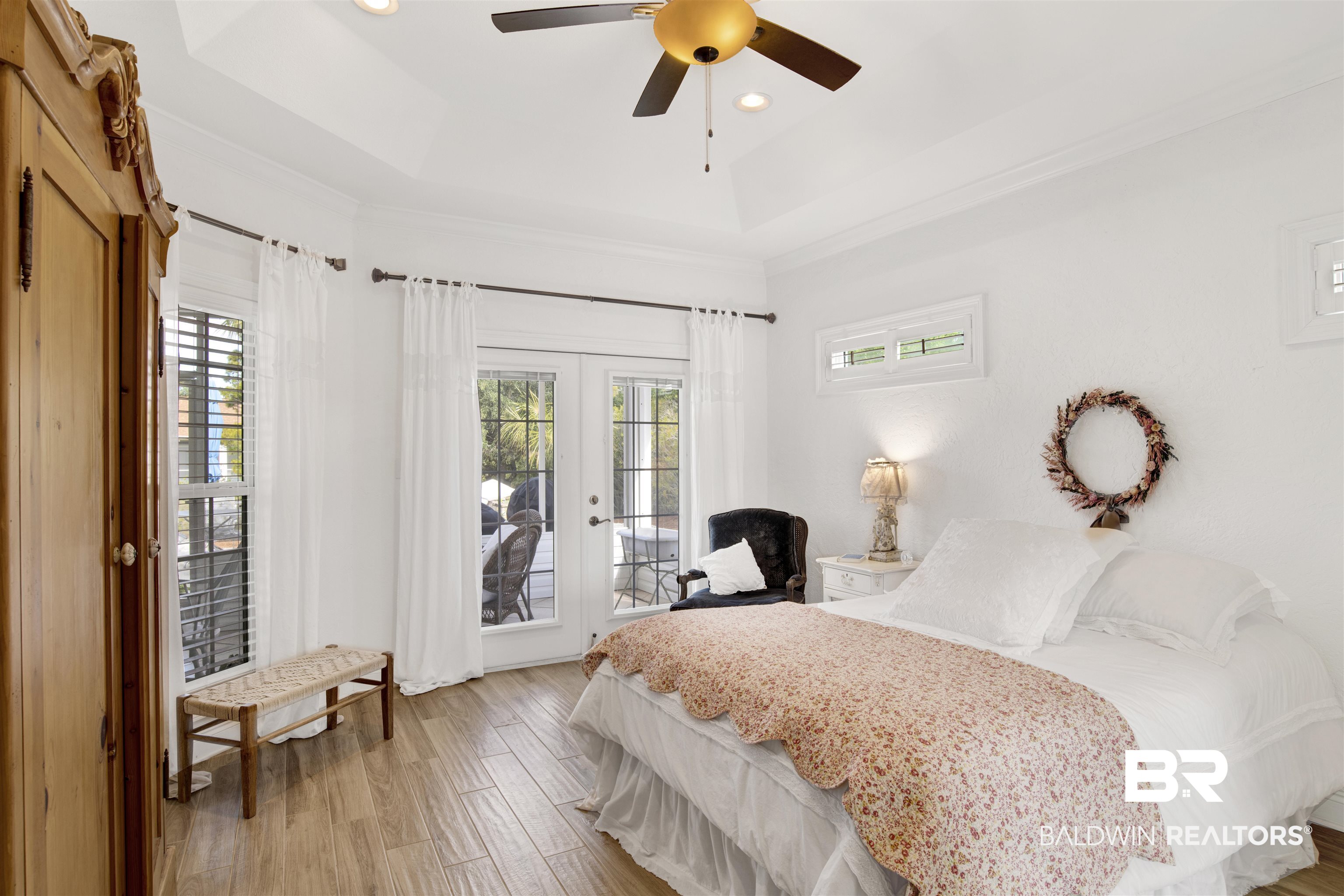 31295 River Road Orange Beach, AL 36561 - Photo 19 of 58 Bedroom with access to exterior, french doors, a raised ceiling, ceiling fan, and light hardwood / wood-style floors
