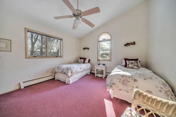 a spacious bedroom with a bed and a chandelier