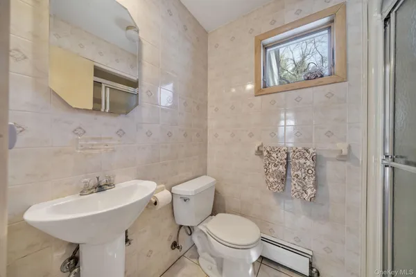 a bathroom with a toilet sink and mirror