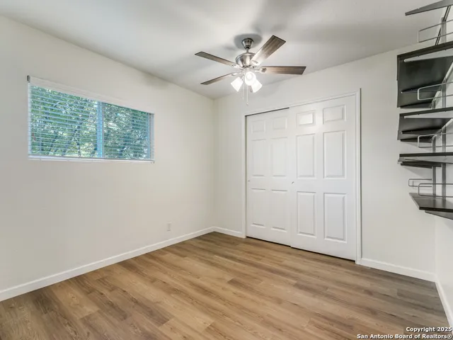 a view of a livingroom with a computer on the desk and a window