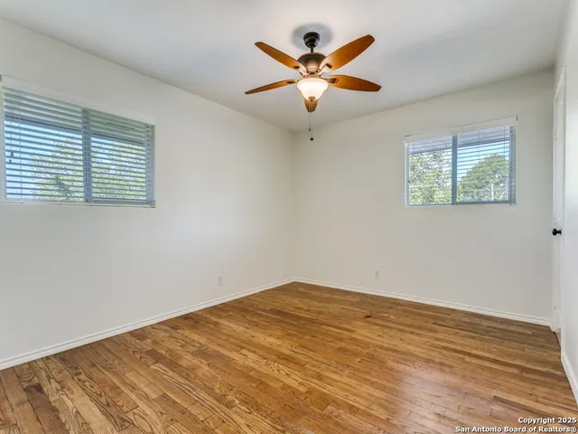a view of a big room with wooden floor and a window