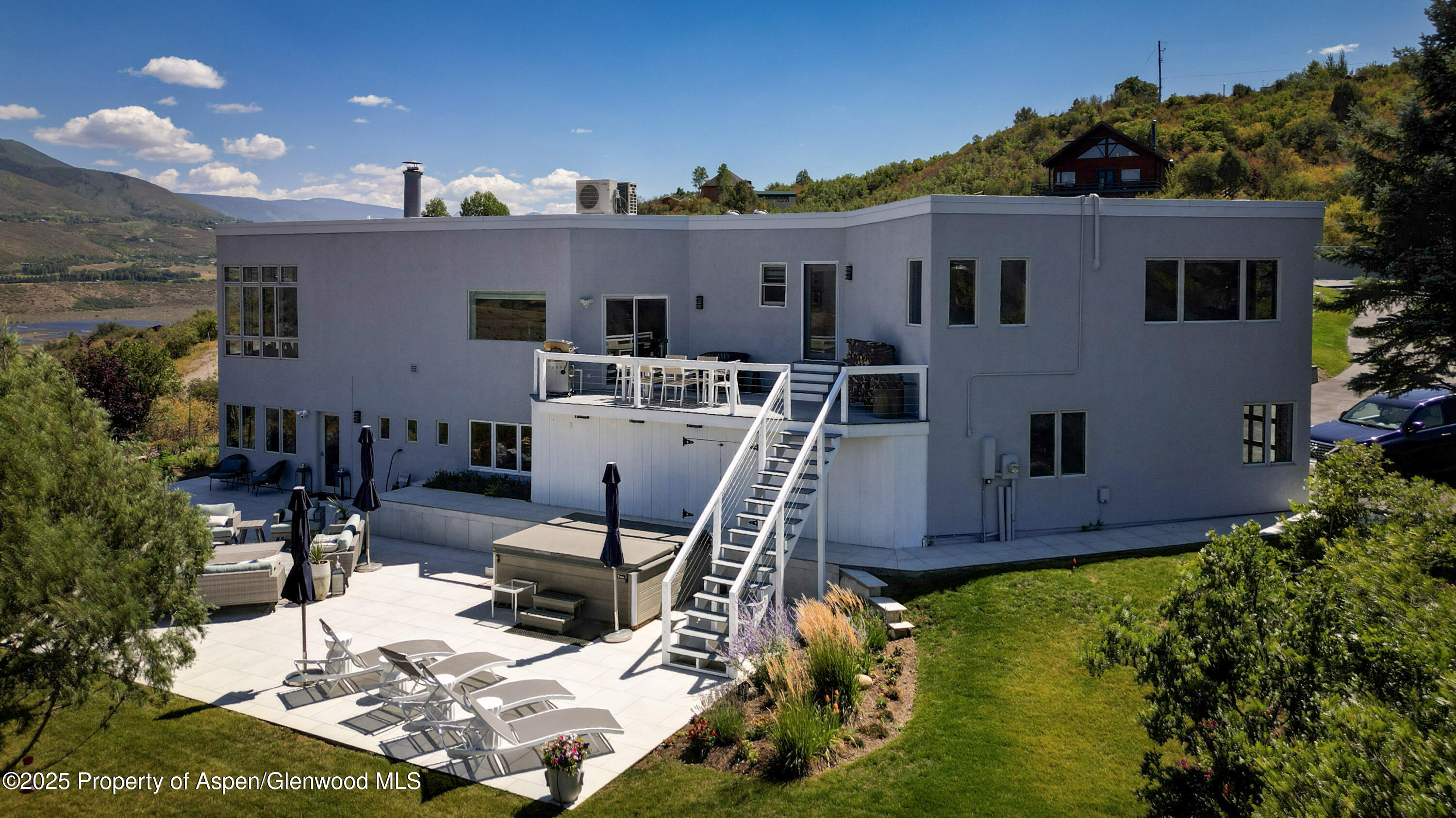 1167 Juniper Hill Road Aspen, CO 81611 - Photo 43 of 60 a view of a patio with table and chairs with plants and wooden fence