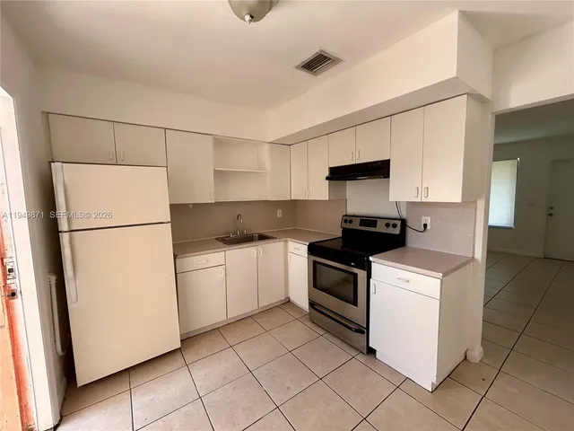a kitchen with a stove a refrigerator and a sink