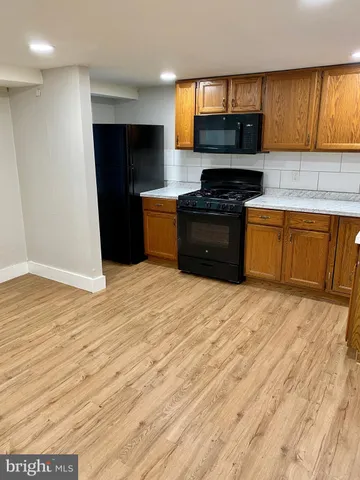 a kitchen with granite countertop a stove top oven a sink dishwasher and a refrigerator