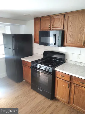a kitchen with granite countertop a stove and a refrigerator