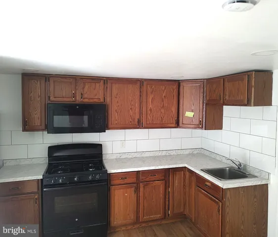 a kitchen with a sink a stove and cabinets