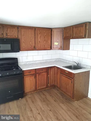 a kitchen with granite countertop wooden cabinets and a stove top oven