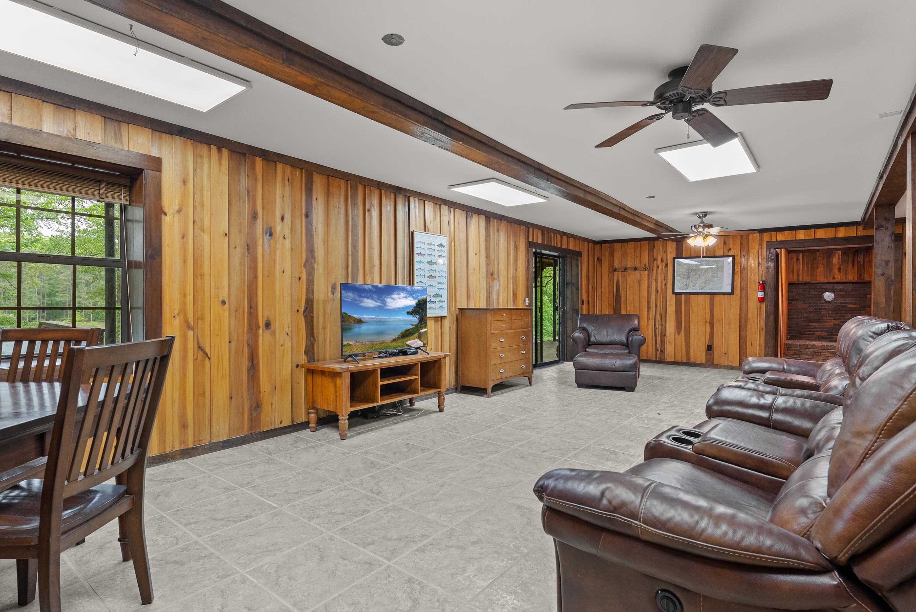 2275 Cypress Road Pocahontas, TN 38061 - Photo 26 of 34 Living area with a skylight, wooden walls, ceiling fan, and beam ceiling
