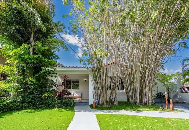 a view of a house with garden and a tree