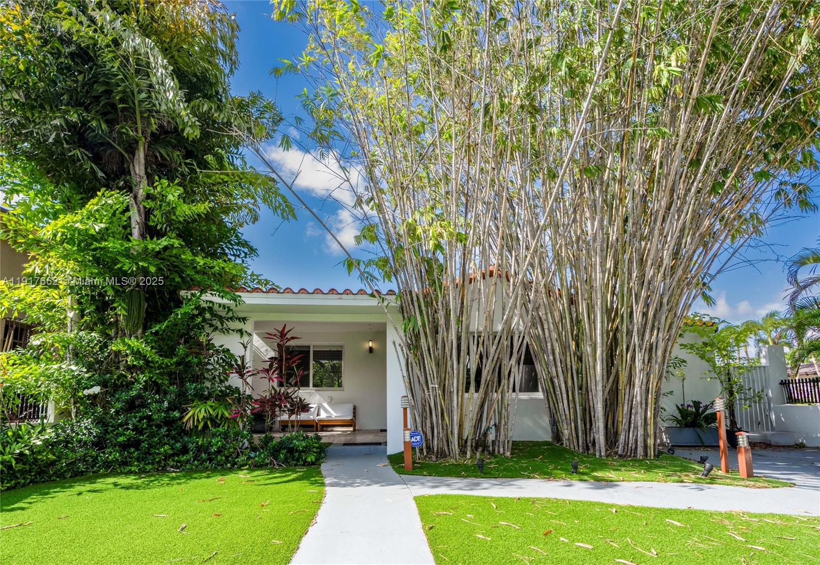 a view of a house with garden and a tree