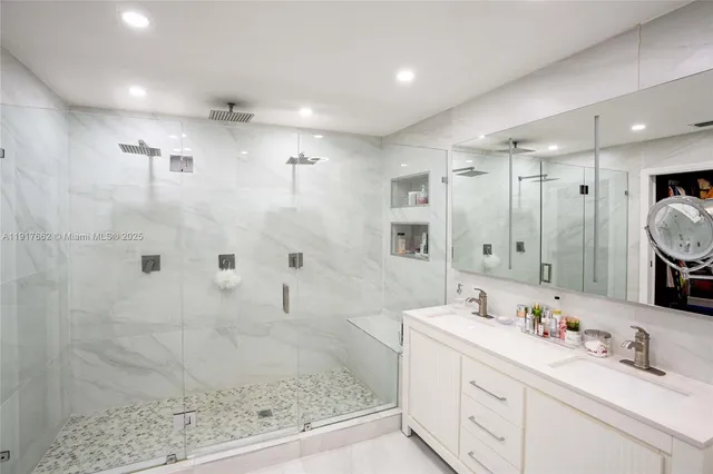 a bathroom with a double vanity sink mirror and shower