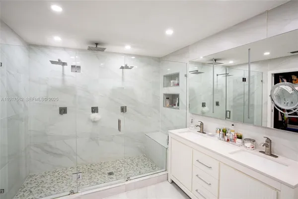 a bathroom with a double vanity sink mirror and shower