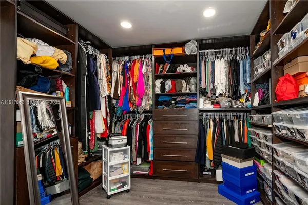 a view of walk in closet with clothes