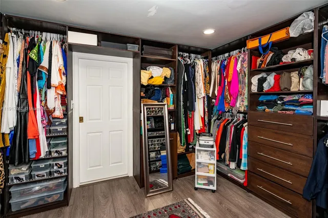 a view of walk in closet with clothes and shoes